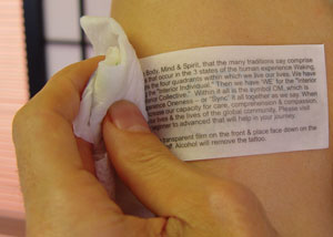A temporary tattoo transfer being applied according to its instructions.